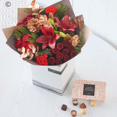 Christmas Bouquet with Chocolates - A quick rundown: a beautiful handcrafted bouquet in festive colours, plus a delicious box of chocolates.

Colour & style: festive favourites. Rich reds, burgundies and greens. Pops of cream and peach. You might see pinecones, scented dried fruit, spruce and pine.

A great gift for: friends and family – or work family.

All the other details:
• This will be handcrafted by their local florist, who will use all their care and skill and make sure it arrives ready to wow.
• It includes a delicious box of chocolates.
• It might not look exactly like the pictures because each bouquet is bespoke, made by hand.
• It's guaranteed to look gorgeous for at least 7 days, or we'll put it right.
• It could feature buds, but they'll open up quickly.
• The packaging is all recyclable or biodegradable.
• It comes with a lovely card, the florist will add your message inside by hand.
• If you have any special requests (like pet-friendly flowers or no lilies), there's a space to add them before you check out. The florist will try their best to help.

Gift contents

Contains:

Milk, Soybeans and Tree Nuts.

May contain:

Peanuts.

This product contains traces of nuts. This product is alcohol free. This product is suitable for vegetarians. This product is NOT suitable for vegans. This product is suitable for Coeliacs.
